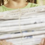 girl recycling newspapers